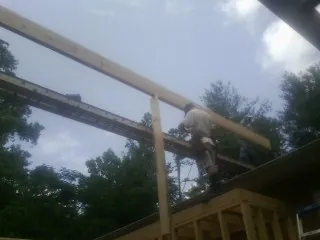 Carpenter setting a ridge beam over a new addition frame — Ice Dam Removal by Roofing Brothers in Bath